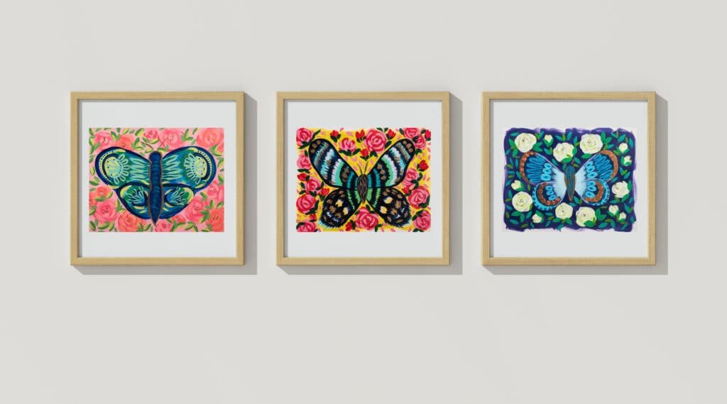 3 butterfly artworks hung in an evenly spaced row, an example of a small grouping hung at eye level