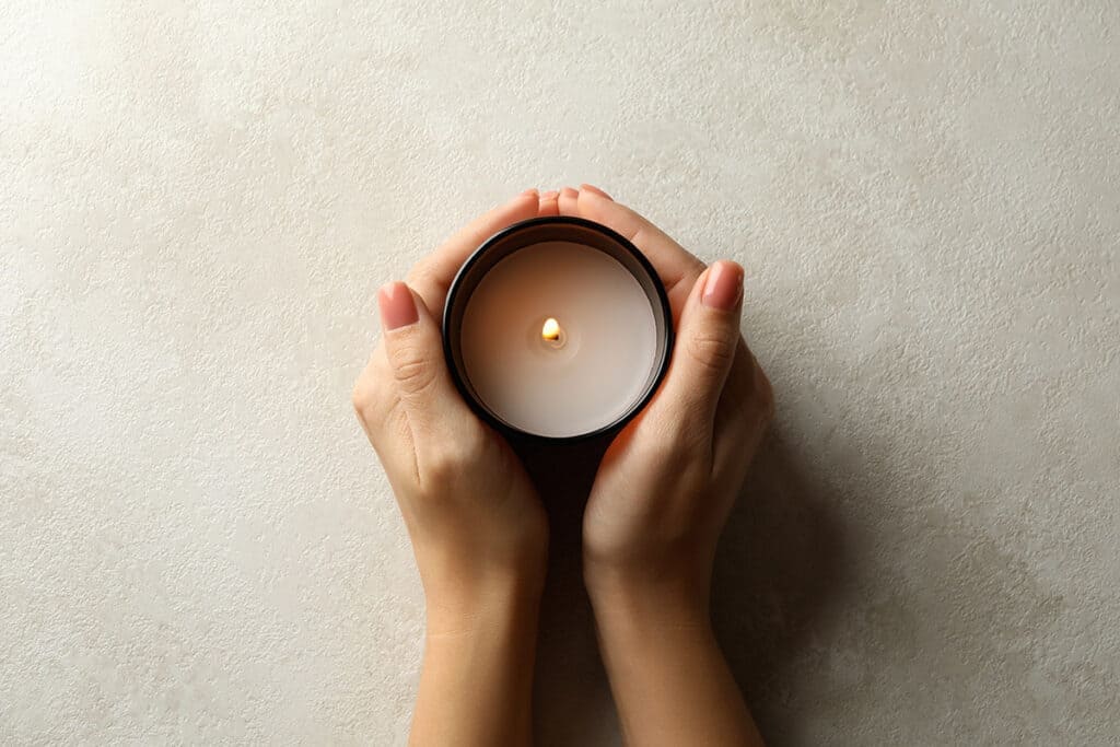 womans hands holding a candle and setting an intention to create a beautiful websites for spiritual entrepreneurs that reflect their energy and essence