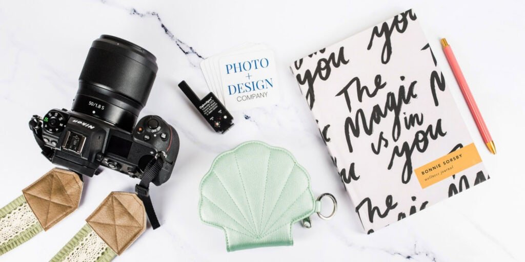 journal reading “the magic is in you” next to Nikon D600 camera and 50mm lens on desk for photography beginners setup