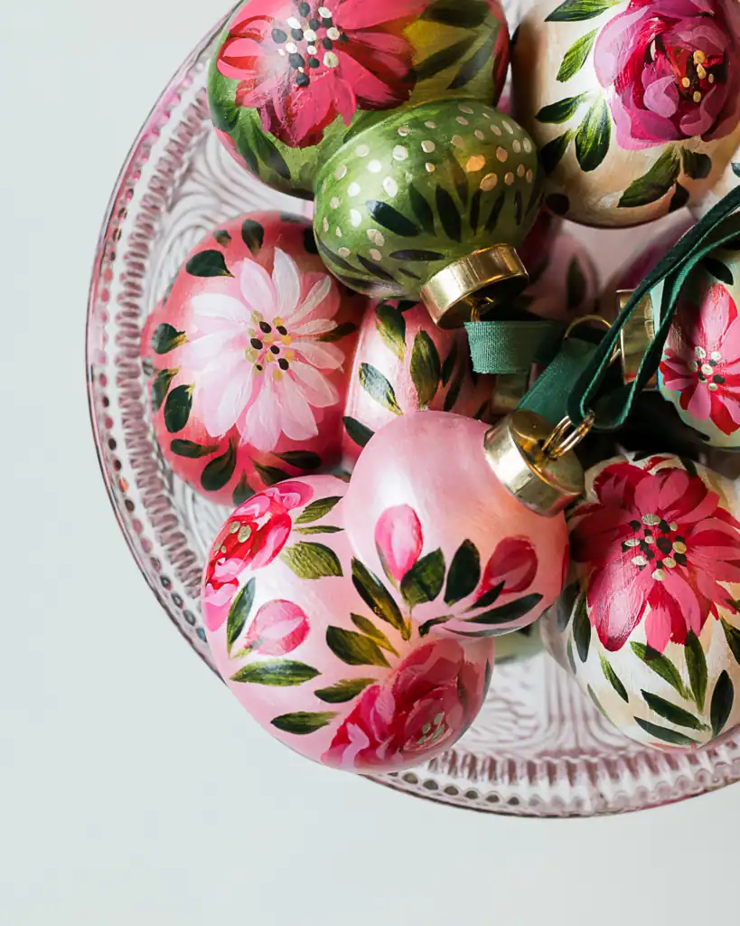 Set of green floral ornaments with white petals and painted leaves, handcrafted artist ornaments for Christmas tree styling.