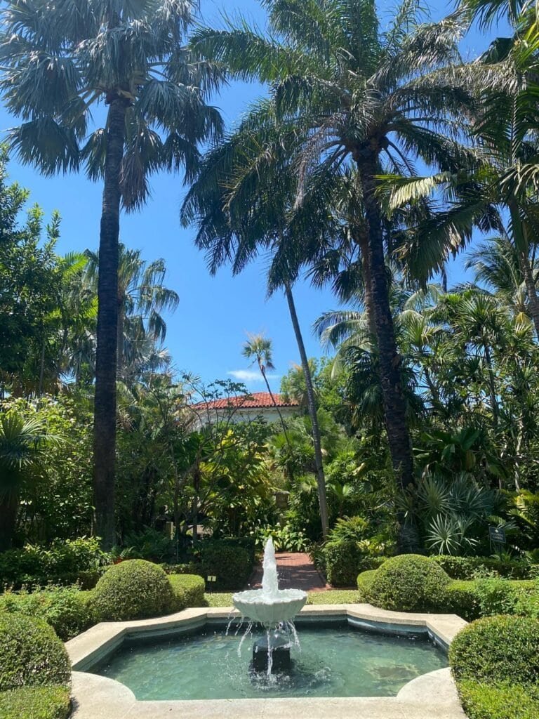 Fountain surrounded by lush greenery at Society of the Four Arts gardens in Palm Beach