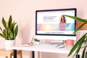 West Palm Beach web design mockup displayed on a computer screen in a modern pink and peach Palm Beach–style room with plants, a coffee mug, and a stylish desk setup.