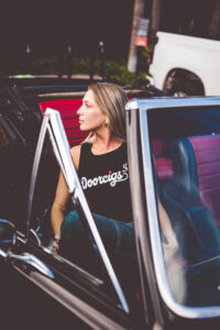 Lifestyle photoshoot for Doorcigs startup brand in Delray Beach — model posing beside classic car during Palm Beach branding session.