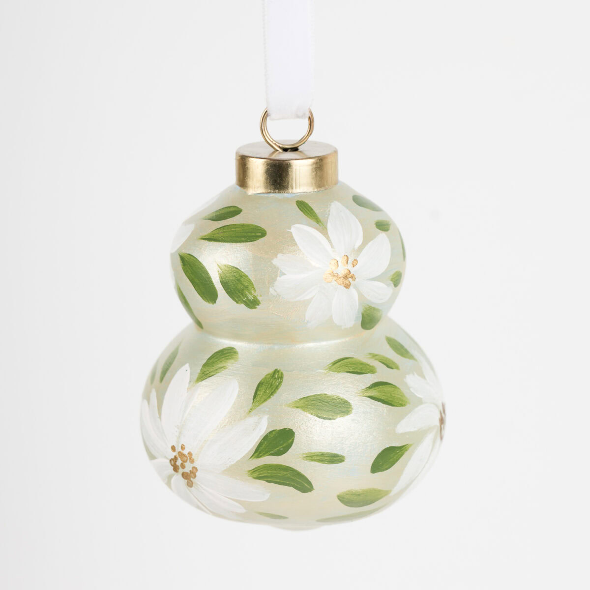 Hand-painted ceramic ornament in white and pale green with botanical florals by Florida artist; grandmillennial and modern cottage holiday style.