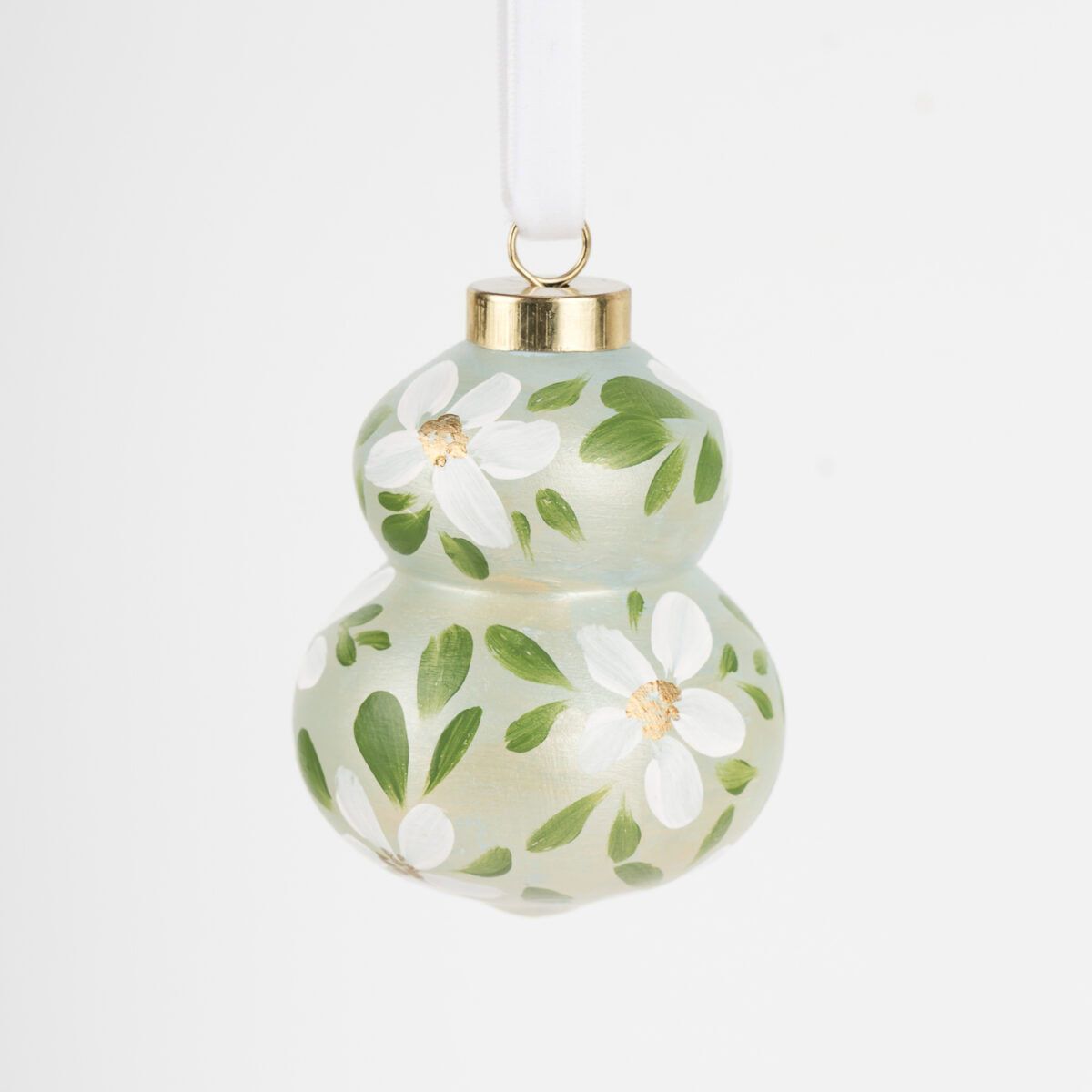 Hand-painted ceramic ornament in white and pale green with botanical florals by Florida artist; grandmillennial and modern cottage holiday style.