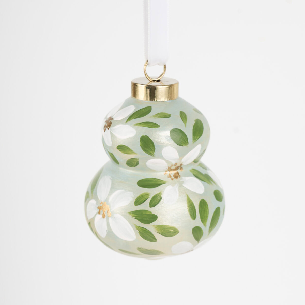 Hand-painted ceramic ornament in white and pale green with botanical florals by Florida artist; grandmillennial and modern cottage holiday style.