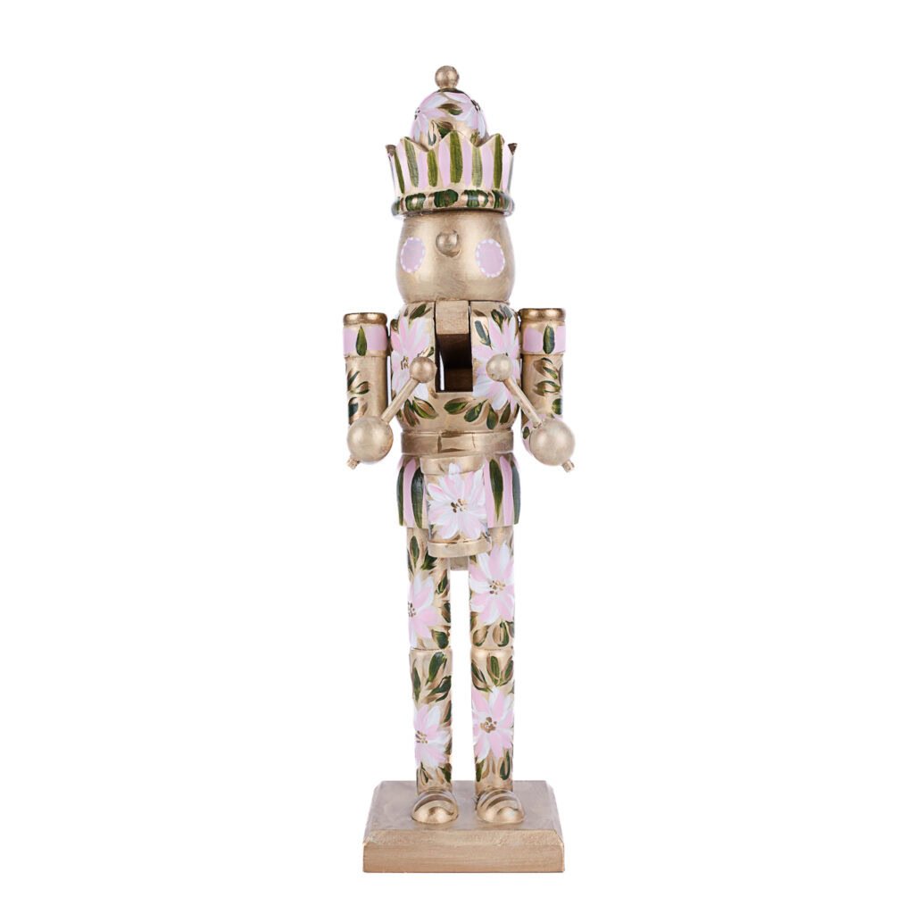 Blush pink floral nutcracker with soft green leaves and gold accents; boho holiday decor by Florida artist.
