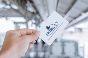 Hand holding Horgan General Contractors business card with modern navy and white logo design