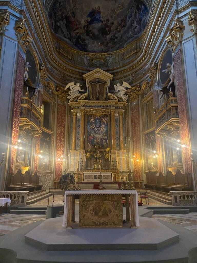 Elegant baroque church with ornate gold accents, intricate frescoes, and a grand altar, showcasing Italy's rich religious and artistic heritage.