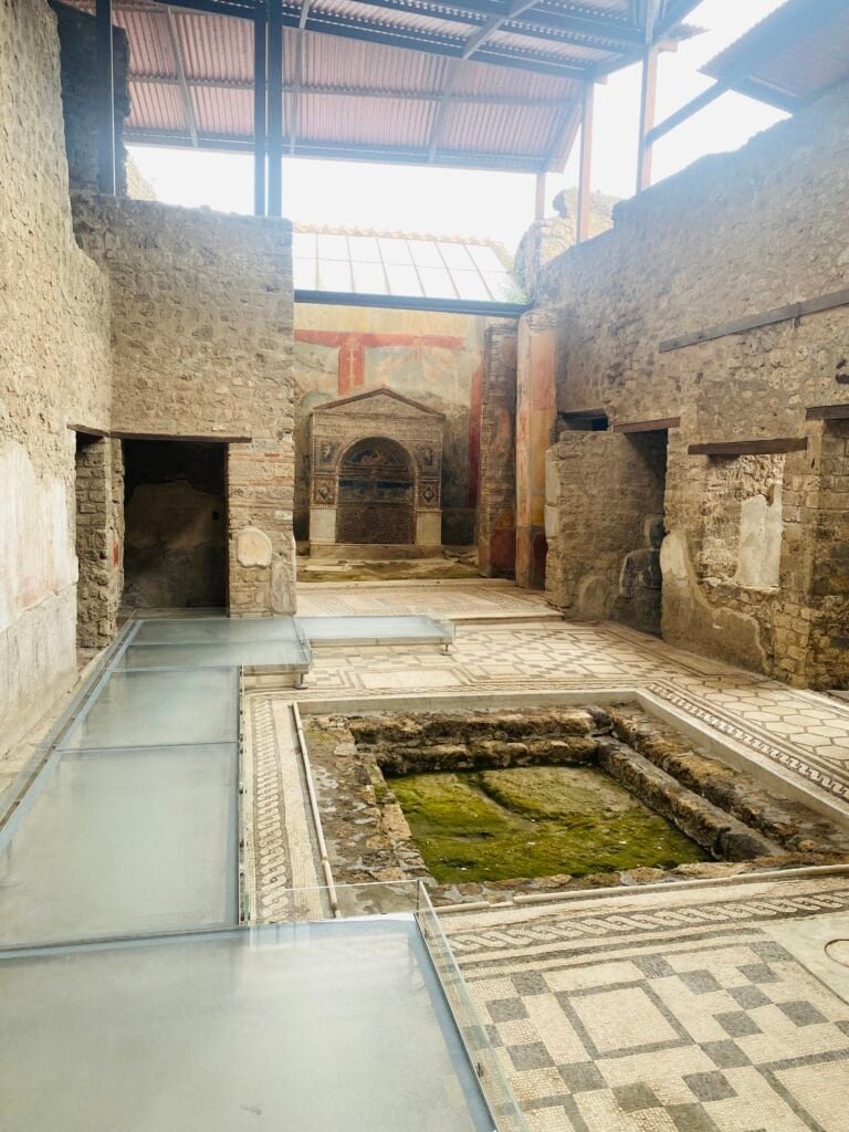 Archaeological site of ancient Roman bathhouse ruins with stone walls, mosaic floors, and remnants of thermal pools in Pompeii, Italy.