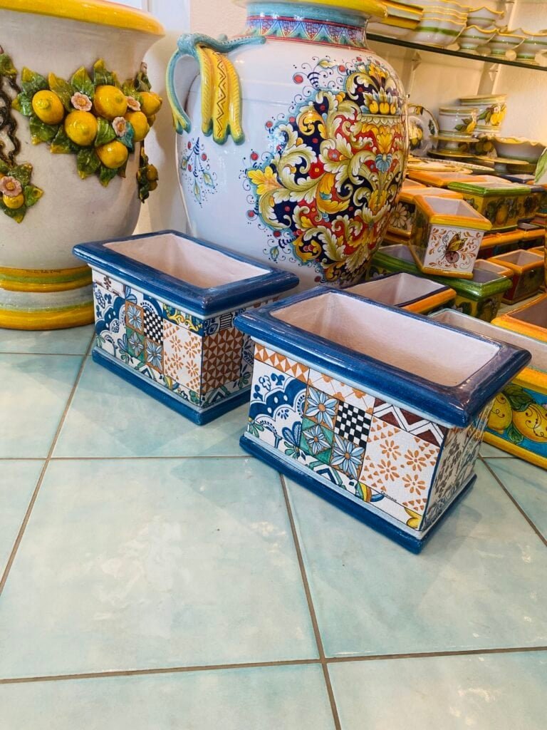 Vibrant ceramic planters and decorative pottery pieces showcased in a colorful shop, highlighting traditional Italian craftsmanship and artistic design.