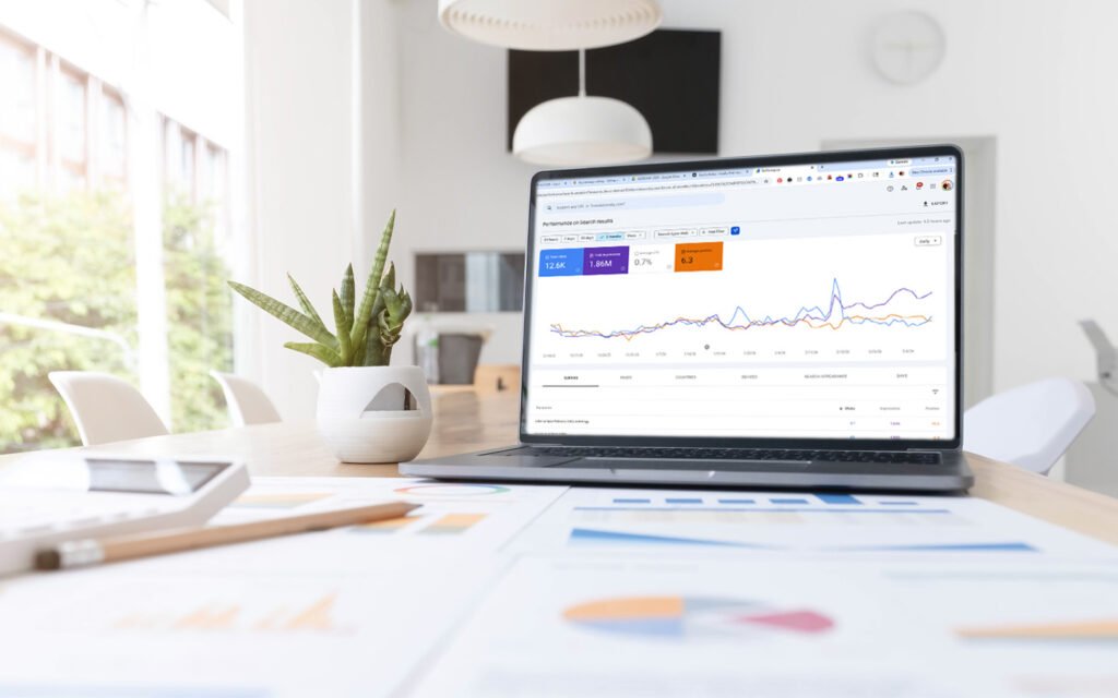 Laptop displaying Google Search Console analytics with increasing organic search traffic in a creative home office workspace of a fractional CMO.