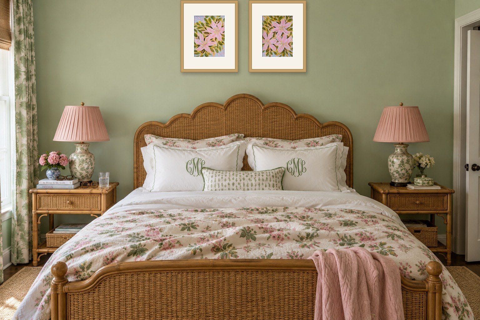 Art above a bed: a pair of framed pink lily paintings by Bonnie Sorsby centered over a scalloped rattan headboard in a celadon green bedroom
