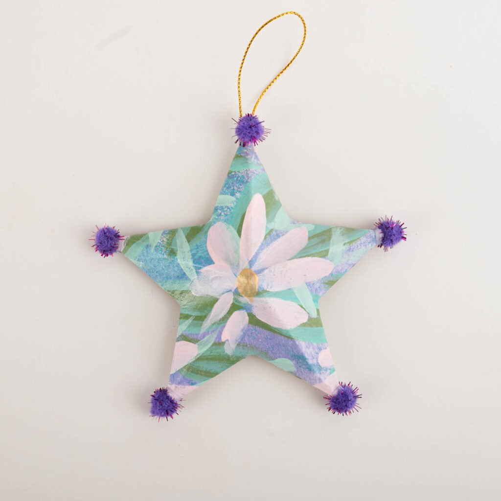 Hand-painted star ornament No. 3 by Bonnie Sorsby, florals in aqua and lavender with pale flowers with purple pom poms on each point and a gold hanging cord