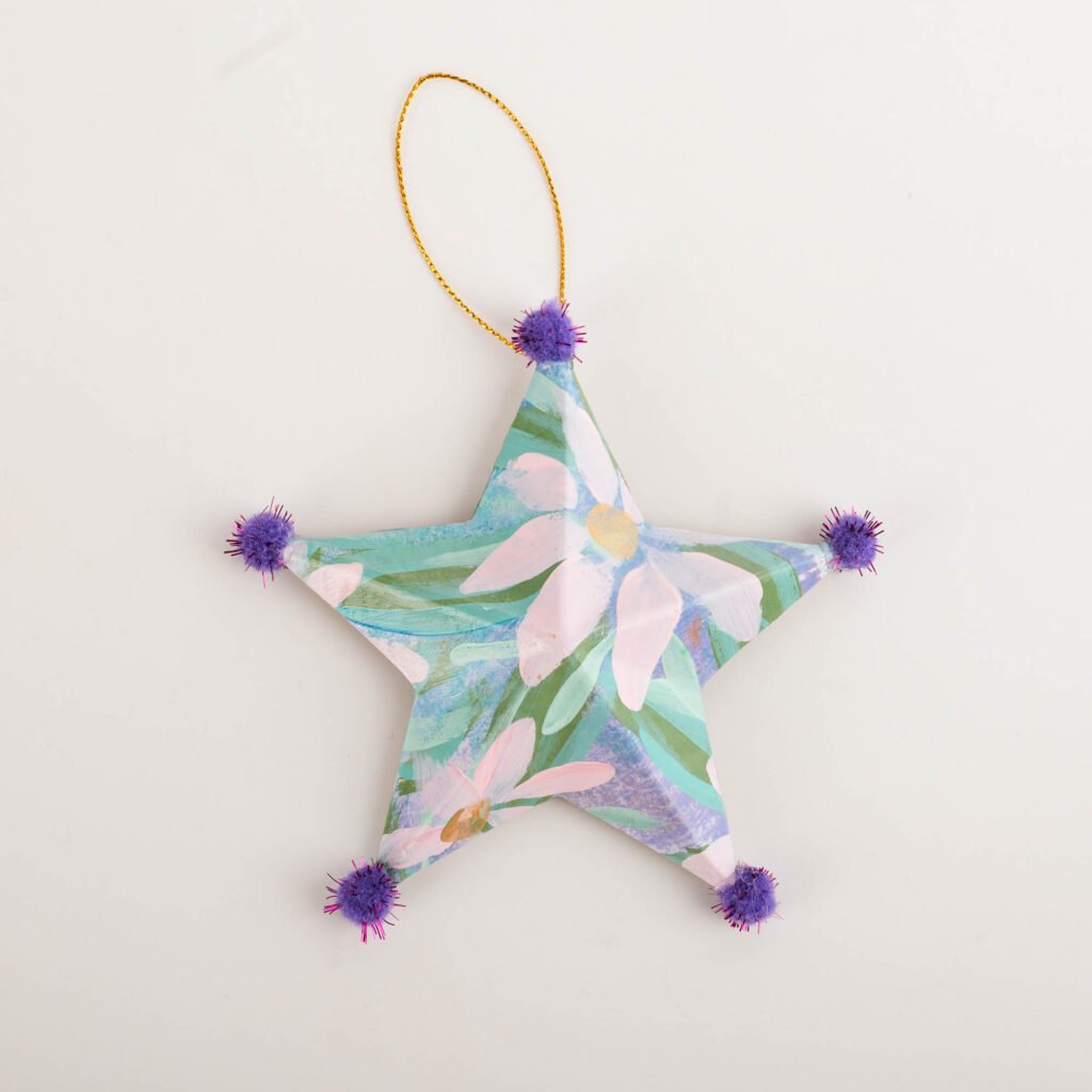Hand-painted star ornament No. 6 by Bonnie Sorsby, florals in lavender and pink florals with violet pom poms on each point and a gold hanging cord