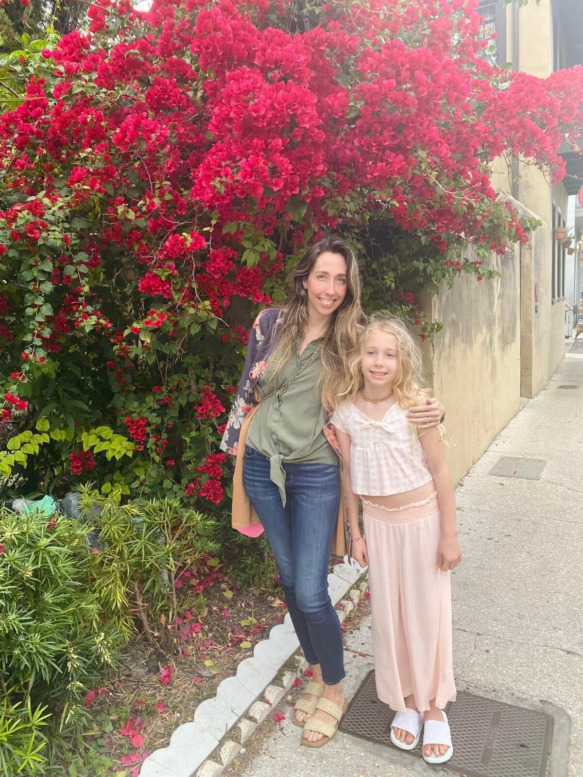 mother and daughter posing in front of a gorgeous pink bougainvillea on vacation in St. Augustine