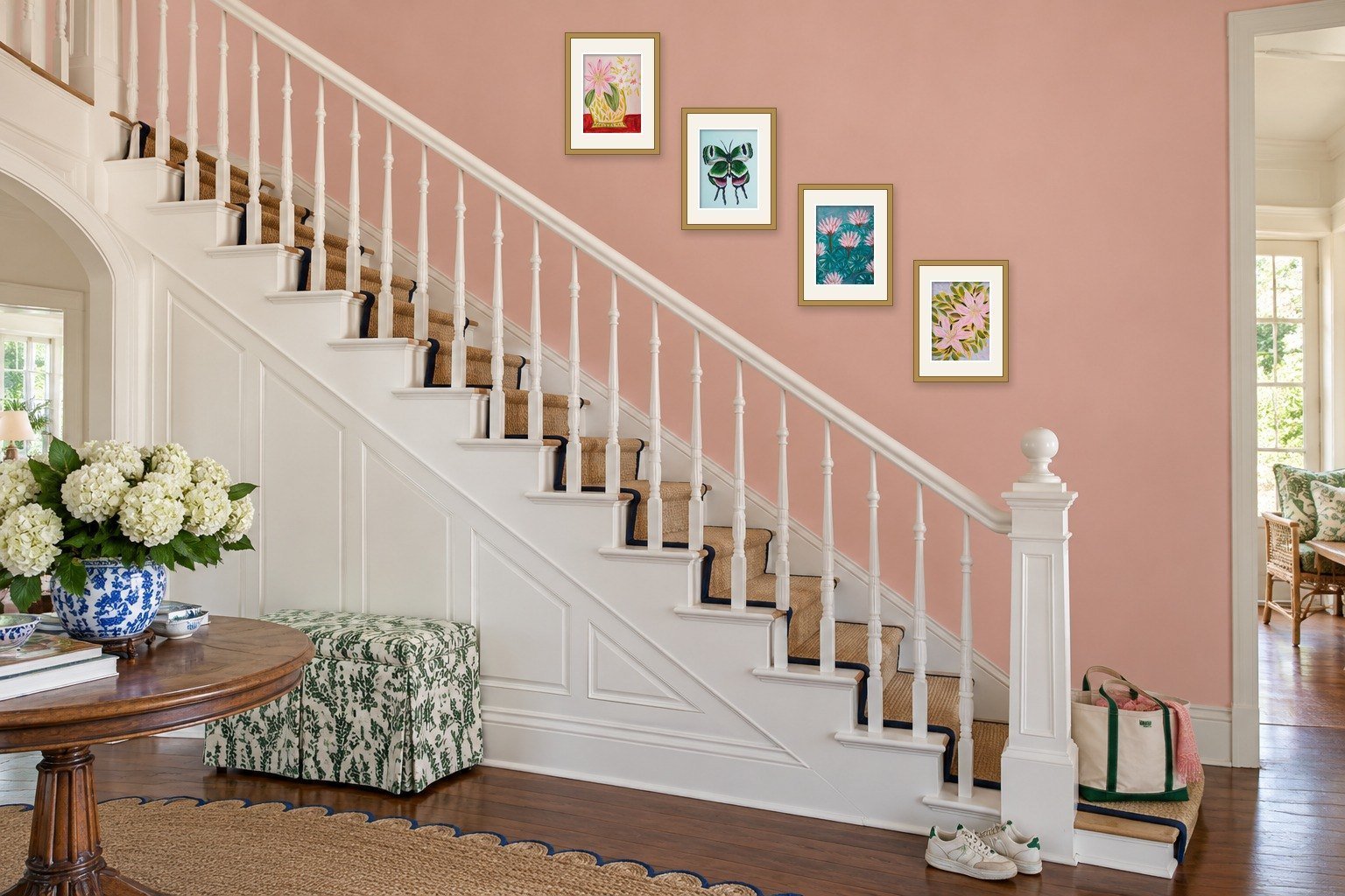 Stairway wall decor: 4 small framed original paintings by Bonnie Sorsby climbing a pink stair wall in a diagonal parallel to the white handrail
